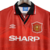 Camisa retrô do Manchester United de 1994/1996, na cor vermelha, com o logo da Umbro e o nome "SHARP" em destaque.

