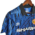 Camisa retrô do Manchester United, modelo azul da temporada 1992/1993, com estampas e detalhes em preto e o logo da Umbro.

