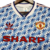 Camisa retrô do Manchester United, modelo azul e branco de 1990/1992, com detalhes em vermelho e logotipo da Adidas.

