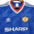 Camisa retrô do Manchester United de 1986/1988 na cor azul, com detalhes em vermelho e logo da Adidas.

