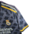 Camisa cinza do Real Madrid temporada 23/24, modelo torcedor da Adidas, com logotipo e detalhes em amarelo.

