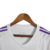 Camisa branca do goleiro do Real Madrid 23/24 com detalhes em roxo e logo da Adidas.

