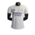 Camisa branca do Real Madrid I 23/24, modelo jogador da Adidas, com detalhes em amarelo e logo do clube.