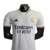 Camisa branca do Real Madrid I 23/24, modelo jogador da Adidas, com detalhes em amarelo e logo do clube.

