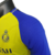 Camisa masculina amarela do Al-Nassr para a temporada 23/24, com detalhes em azul e logo da equipe.

