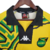 Camisa retrô da seleção da Jamaica de 1998, na cor amarela, com detalhes em verde e preto.

