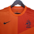 Camisa retrô laranja da Seleção da Holanda, modelo masculino da Nike, com detalhes em preto e o símbolo da KNVB.

