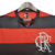 Camisa retrô do Flamengo, nas cores vermelha e preta, com listras horizontais e logo do clube.