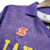 Camisa retrô da Fiorentina da temporada 1989/1990 na cor roxa, com o logo do time e a inscrição "LA NAZIONE".

