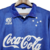 Camisa retrô do Cruzeiro, cor azul, com logo da Finta e estampa da Coca-Cola.

