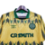 Camisa retrô do Celtic Football Club, temporada 1991/1992, nas cores amarela e verde, com detalhes gráficos e o logo da Umbro.

