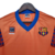 Camisa retrô laranja do Barcelona, modelo 1989/1992, com detalhes em azul e logo do time.

