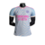 Camisa de treino do Arsenal 23/24, modelo masculino, branca com detalhes em rosa e azul, com logo da Adidas.