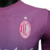 Camisa AC Milan III 23/24 masculina da Puma, rosa com detalhes em roxo e verde, exibida em um manequim.

