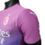 Camisa AC Milan III 23/24 masculina da Puma, rosa com detalhes em roxo e verde, exibida em um manequim.

