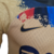 Camisa masculina da Barcelona Edição Especial 23/24, bege com detalhes em azul e vermelho, com logotipo da Nike e Spotify.

