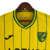 Camisa amarela do Norwich City I 22/23, com detalhes em verde e preto e logo da marca Joma.

