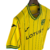 Camisa amarela do Norwich City I 22/23, com detalhes em verde e preto e logo da marca Joma.

