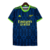 Camisa de treino do Arsenal para a temporada 23/24, na cor azul com detalhes em amarelo e verde, com logotipo da Adidas e inscrição "Emirates Fly Better".