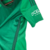 Camisa Osasuna II 23/24 na cor verde com detalhes em branco, com o logo da Adidas e a inscrição 'KOSNER'.

