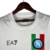 Camisa branca do Napoli, edição especial 23/24, com detalhes em vermelho e verde, estampada com 'Campioni d'Italia 22/23' e o logo da EA7.

