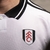 camisa-titular-home-casa-número-i-1-um-fulham-fc-2024-2025-23-24-adidas-branca-craven-cottage-arcos-vermelhos-gola-polo-preta-tradicional-tres-listras-pretas-detalhes-arquitetura-selo-especial-nuca-escudo-clube-patrocinio-sbotop-6