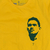 Camiseta amarela com estampa do rosto de Garrincha, jogador de futebol brasileiro, e o número 7 abaixo.