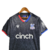 Camisa Crystal Palace III 23/24 - Torcedor Macron Masculina - Preta com detalhes em vermelho e azul - CAMISAS DE FUTEBOL | Footfy Sports