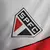 Detalhe do logo do São Paulo FC em uma camisa retrô preta, branca e vermelha, edição memorial 1992 da Adidas.