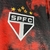 Emblema da camisa do São Paulo FC, destacando as cores preta e vermelha com cinco estrelas acima do escudo.