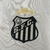 Logotipo bordado do Santos Futebol Clube em uma camisa branca.