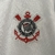 Emblema do time Corinthians em uma camisa masculina torcedor, destacando os elementos náuticos e a bandeira do clube.