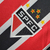 Detalhe do brasão da camisa São Paulo II 24/25, com as cores tricolores e estrelas representando títulos.