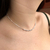 Choker de bolinhas prateadas em pescoço feminino, destacando seu design elegante e delicado.