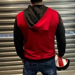 Homem de costas usando um moletom premium MOTOLIKE da marca LK-LIKE, em vermelho e preto, segurando um capacete de corrida.