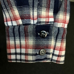 Punho de uma camisa xadrez premium da marca LK-LIKE, com botões prateados e padrão em vermelho, azul e branco.