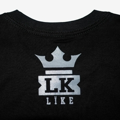 Camiseta preta da marca LK-LIKE com estampa prata, destacando as letras "LK" e uma coroa