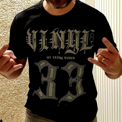 Homem usando uma camiseta preta da marca LK-LIKE com estampas em cinza e fazendo o símbolo de rock com as mãos.