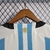 Detalhe das costas da camisa da seleção da Argentina, com listras azul e branca e o emblema da seleção.