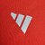 Detalhe do logo da Adidas em uma camisa vermelha feminina do Internacional, modelo 24/25.