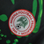 Emblema da Federação Nigeriana de Futebol em uma camisa preta com detalhes verdes.