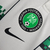 Detalhe do logo da Federação Nigeriana de Futebol em uma camisa branca com detalhes em verde da Nike.