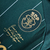 Detalhe da camisa do Sporting Lisboa 24/25, mostrando o logotipo do clube em dourado e uma frase estilizada.