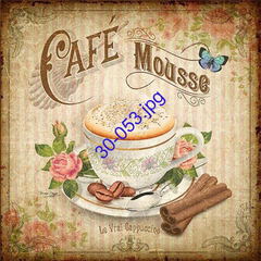 Taza de café mousse decorada con flores y granos de café, acompañada de canela.