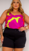 Modelo usando blusa regata feminina plus size Helena, com estampa colorida em tons de rosa e verde, combinada com shorts pretos.