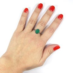 detalhe na mão do anel semijoia de pedra oval cristal esmeralda leitosa com aro torcido banhado a ródio negro