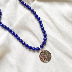 detalhe do colar semijoia de pedras naturais jade azul facetada e pingente amuleto proteção e sorte banhado a ródio branco