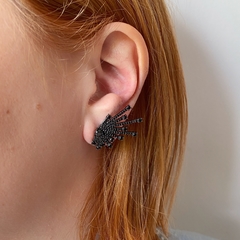 detalhe na orelha do brinco semijoia earcuff setas cravejado de zircônias negras banhado a ródio negro