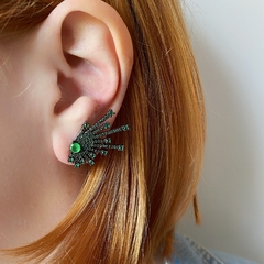 detalhe na orelha do brinco semijoia earcuff setas cravejado de zircônias esmeraldas banhado a ródio negro