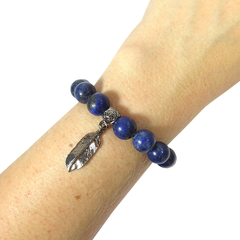 detalhe no pulso da pulseira japamala semijoia de lapis lazuli e pingente pena banhado a ródio negro